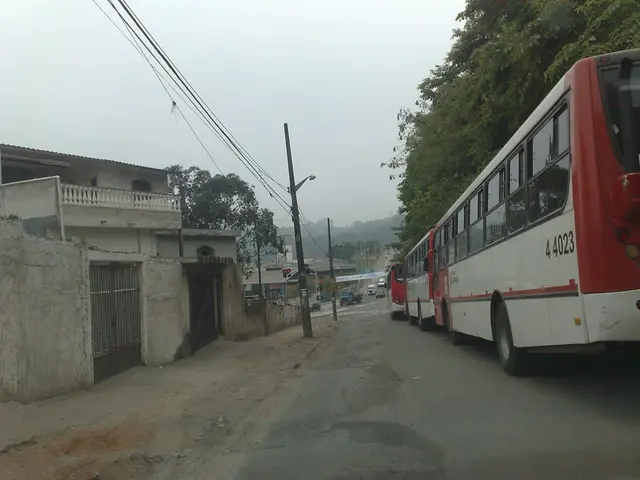 There are few vehicles on the road in the right corner and there are few buildings,poles and wires...