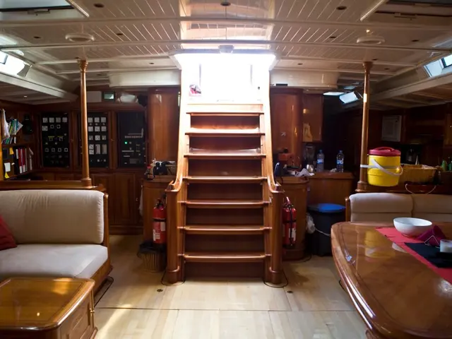 In this image, we can see sofa, pillow, a wooden table, floor, wooden dining table. On top of it,...