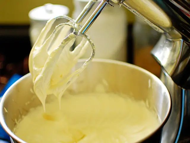 In the picture we can see blender machine and a container with some food item. The background of...